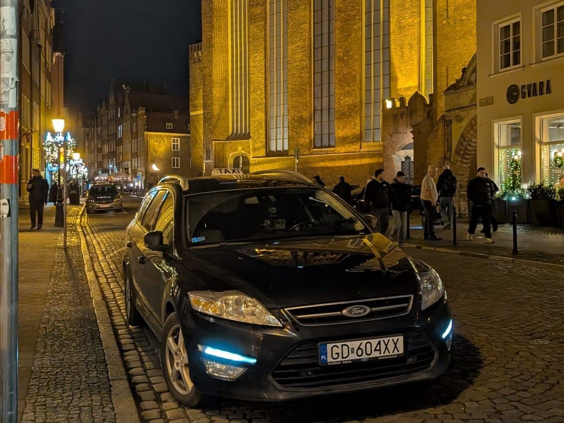 Taksówka TapTaxi na gdańskiej starówce przy Bazylice Mariackiej nocą